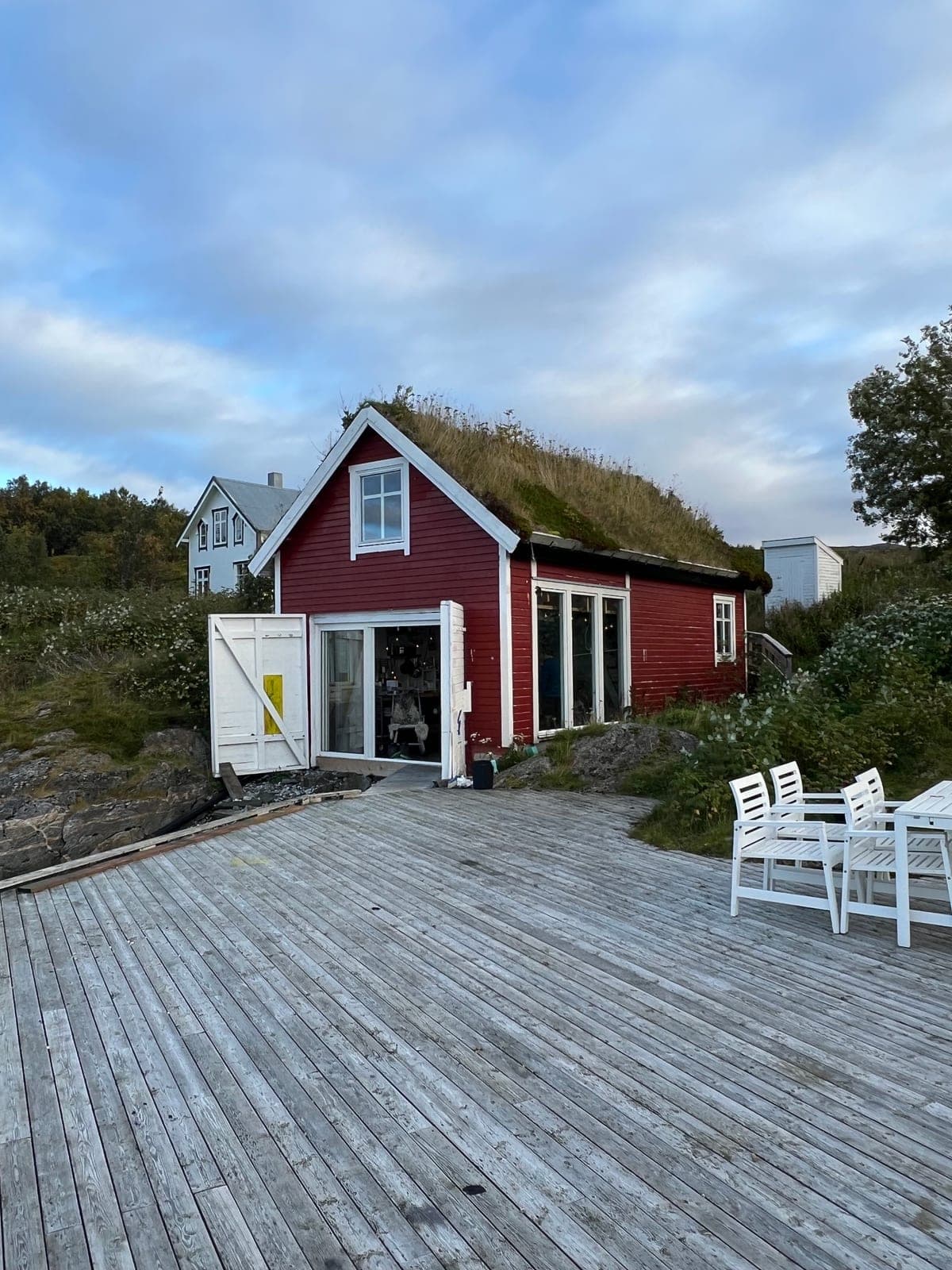 The Sea Lodge, red with a turf roof, doors open onto the dock
