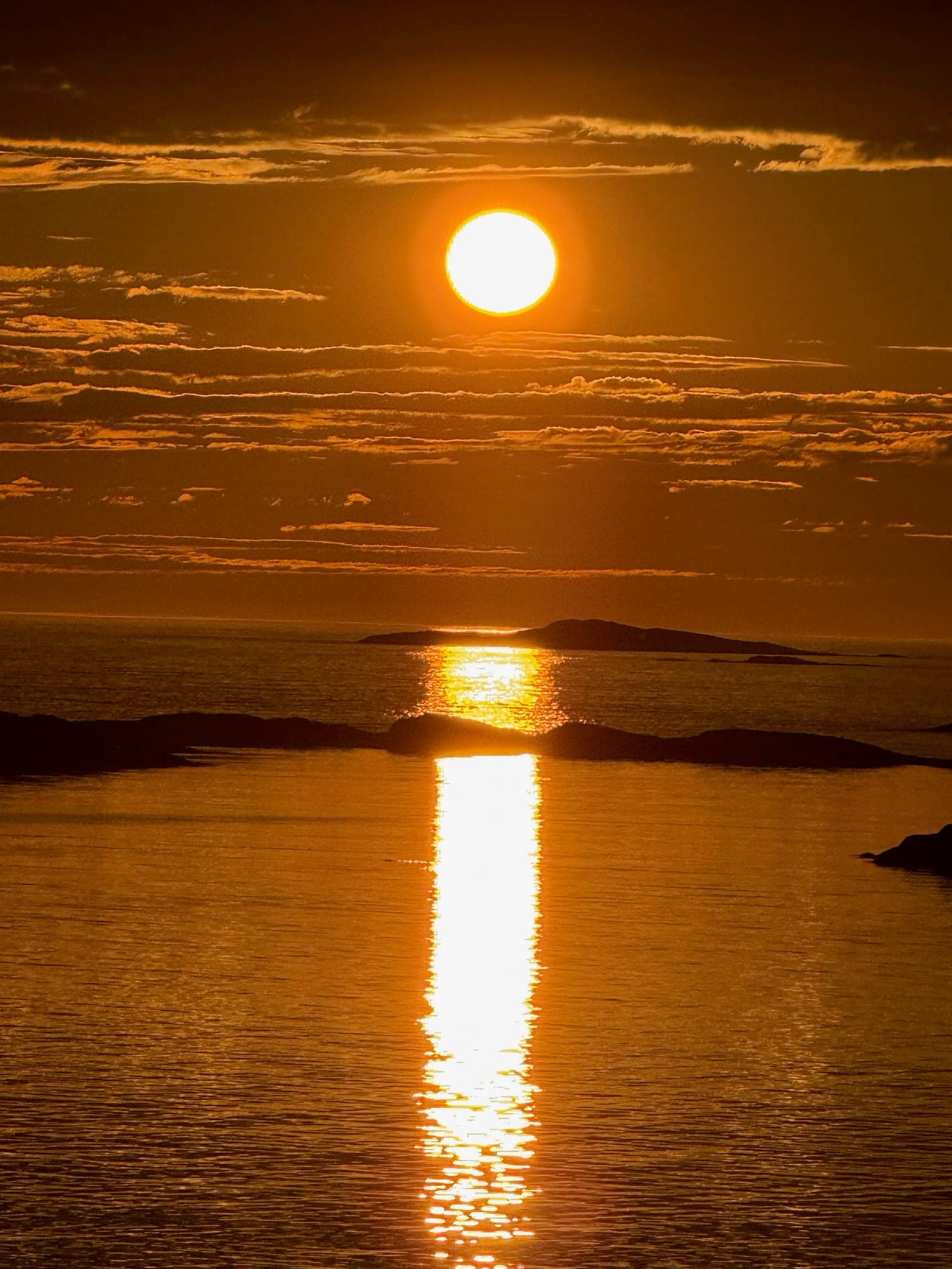 The midnight sun low over the sea and skerries
